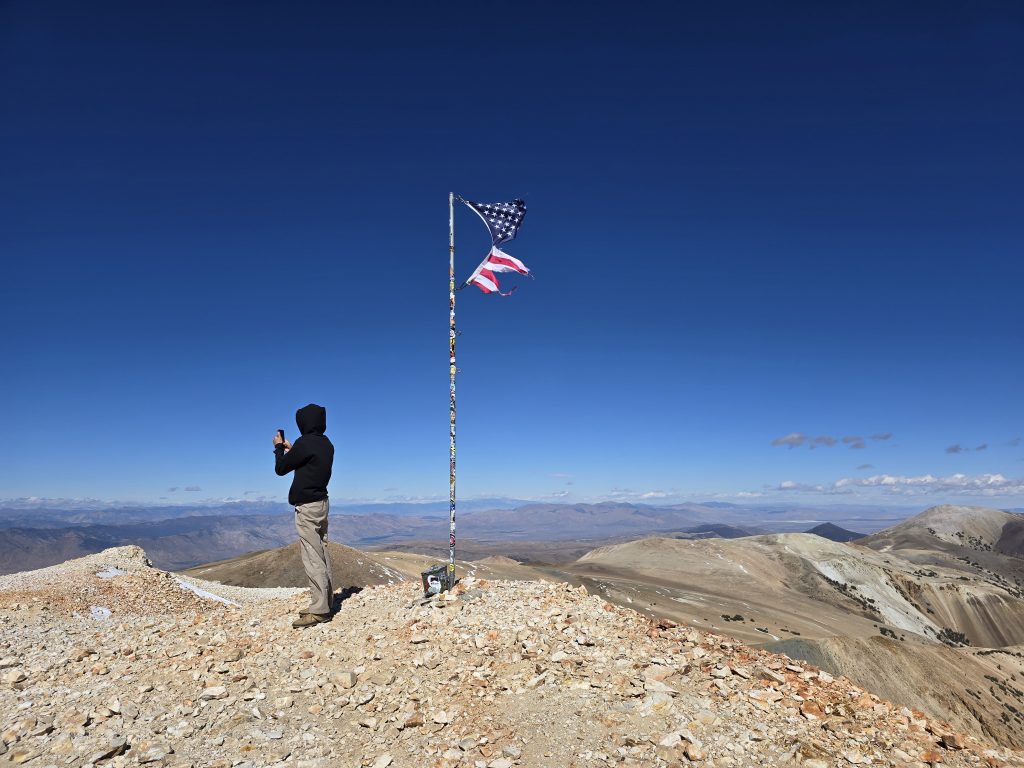 Standing near the American flag at the top of Mt. Patterson