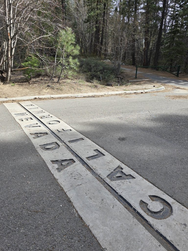 Nevada/California state line marking on the road through Van Sickle Bi-State Park