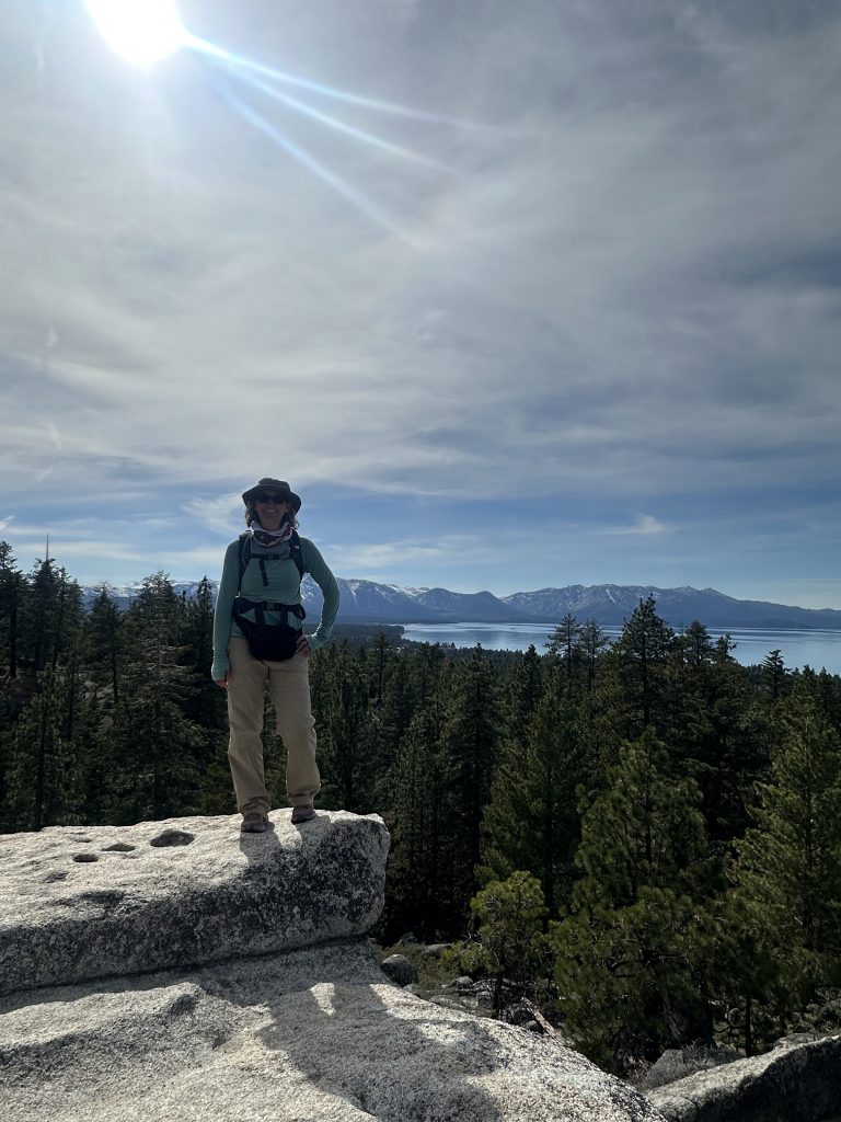 Standing on the boulders at a scenic overlook of Lake Tahoe on Van Sickle Rim Trail in Van Sickle Bi-State Park