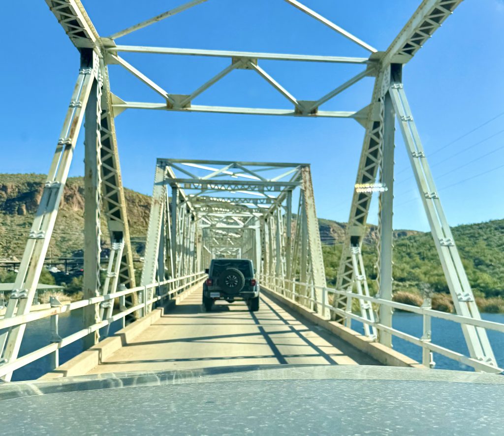 Driving on the one-lane bridge across Boulder Creek on Apache Trail Highway 88 near Boulder Canyon Hike trailhead
